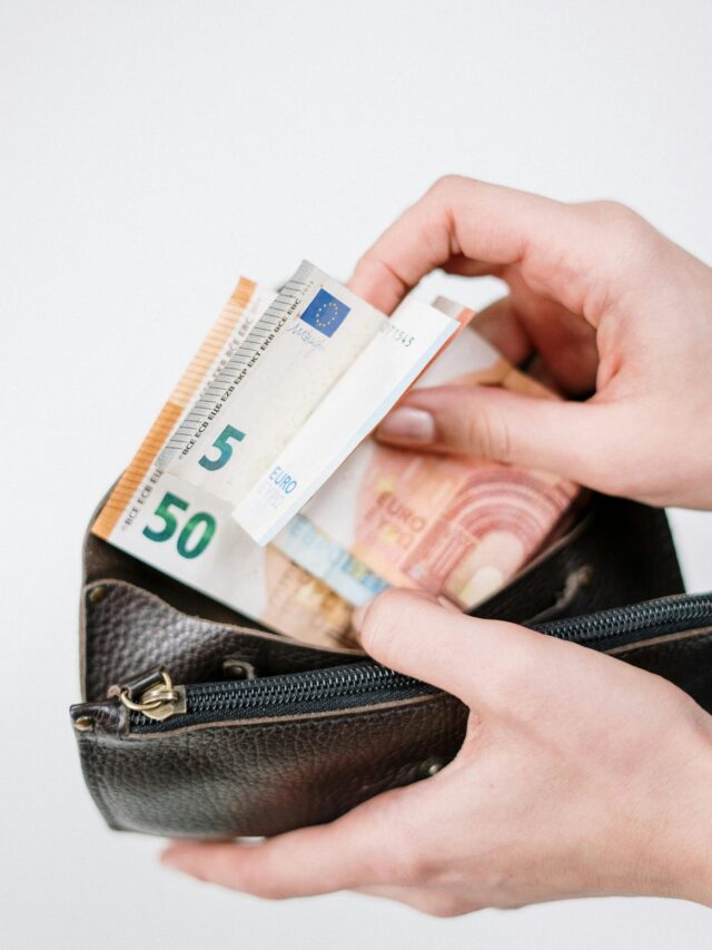 Close-up of hands with euro banknotes being placed in a wallet. Ideal for finance-related content.