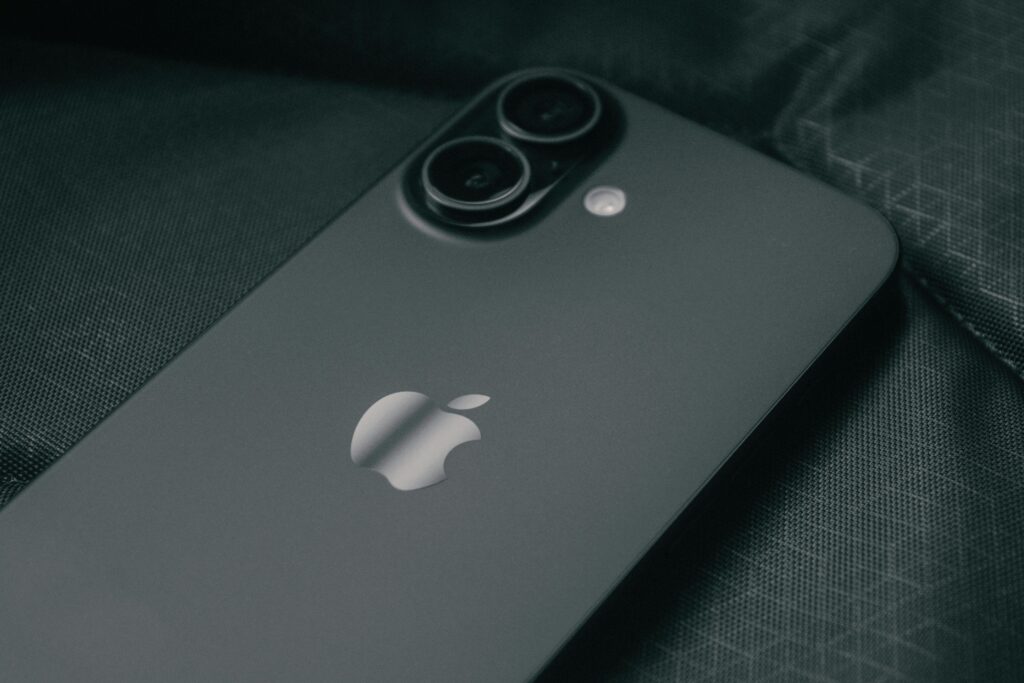 Detailed close-up of a modern smartphone on a textured dark fabric background.