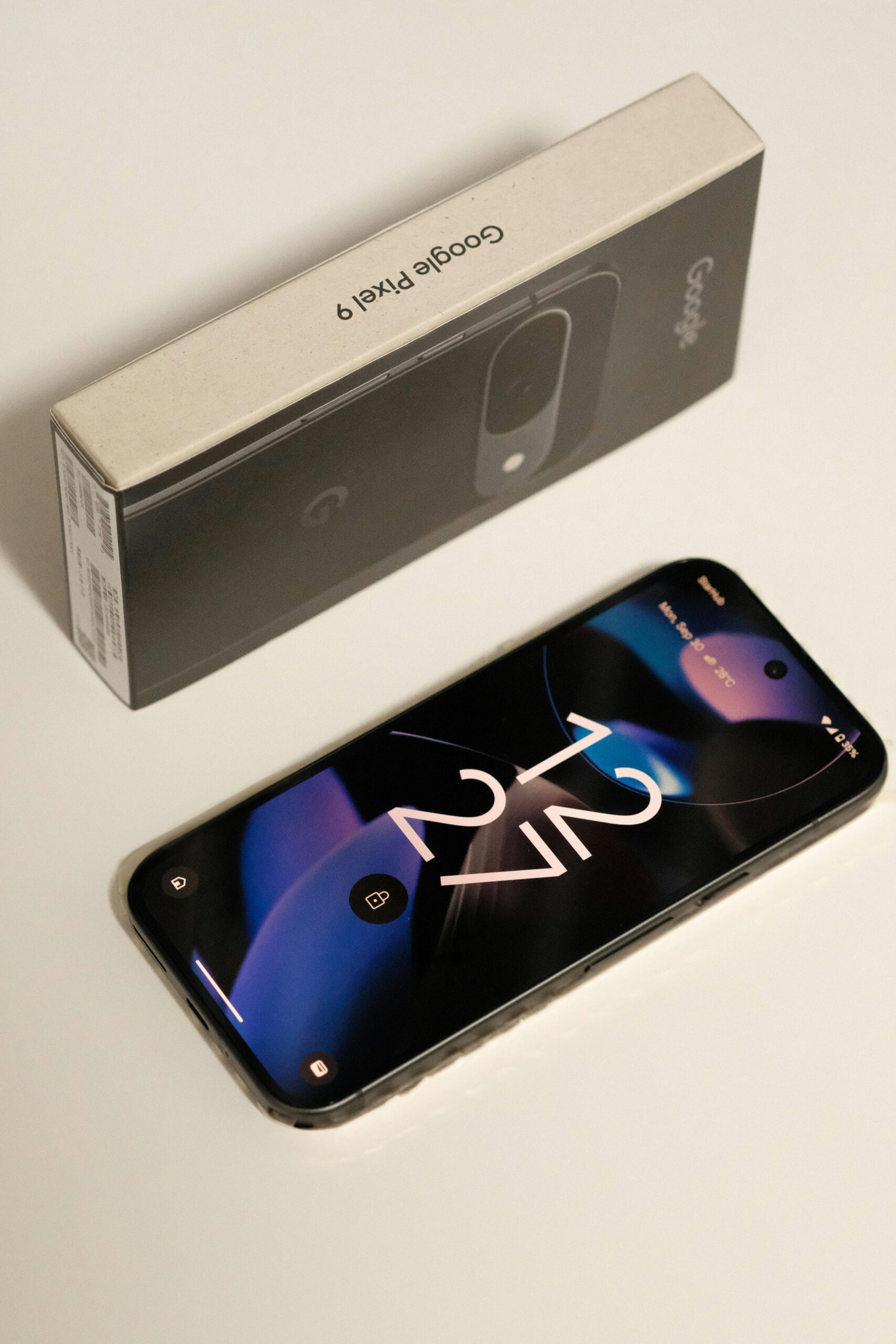 Close-up of Google Pixel 9 smartphone with the original packaging box, showcasing sleek design.